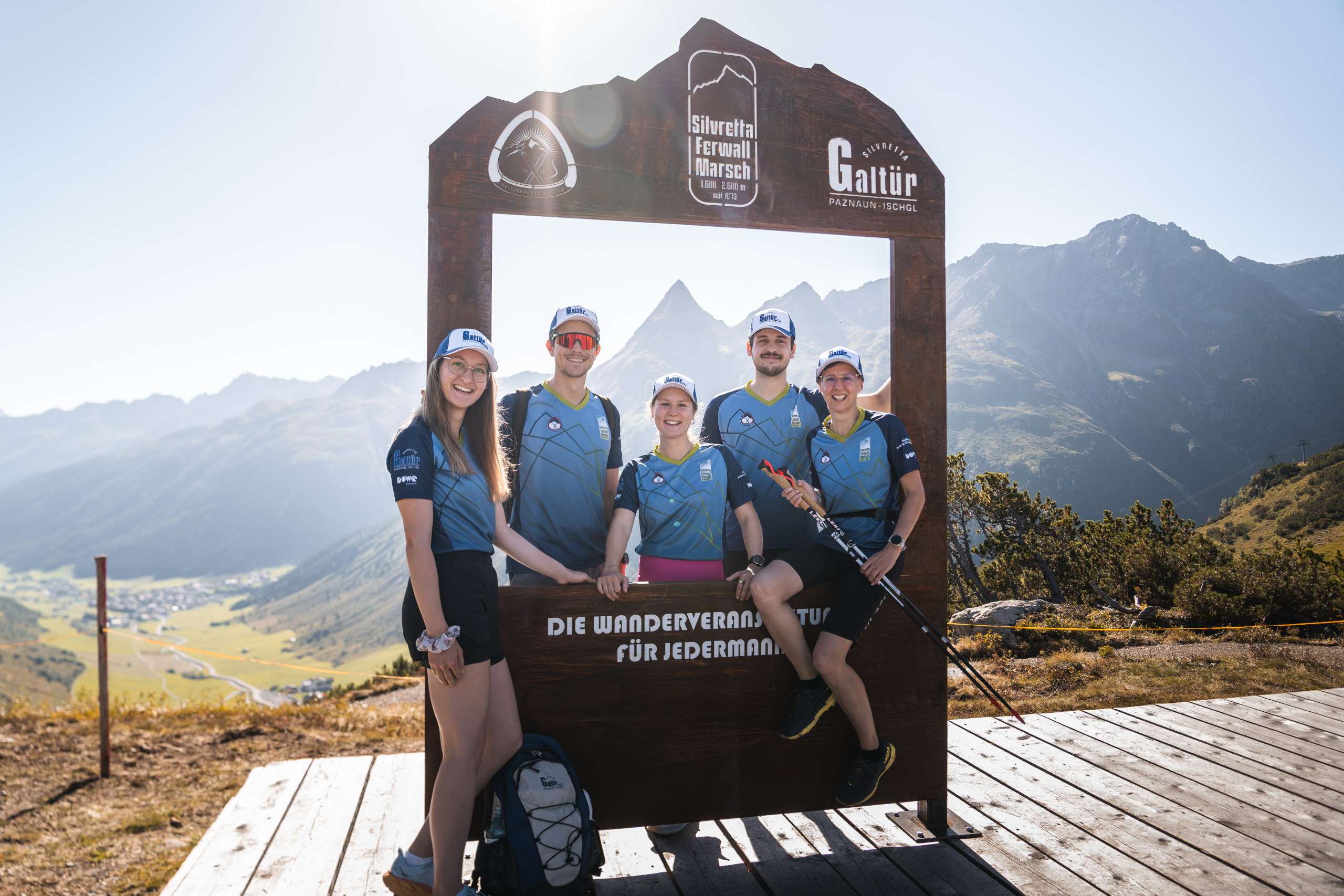 Fünf Athletinnen auf einer Bergspitze beim Posieren in blauen Sport-Shirts von DOWE