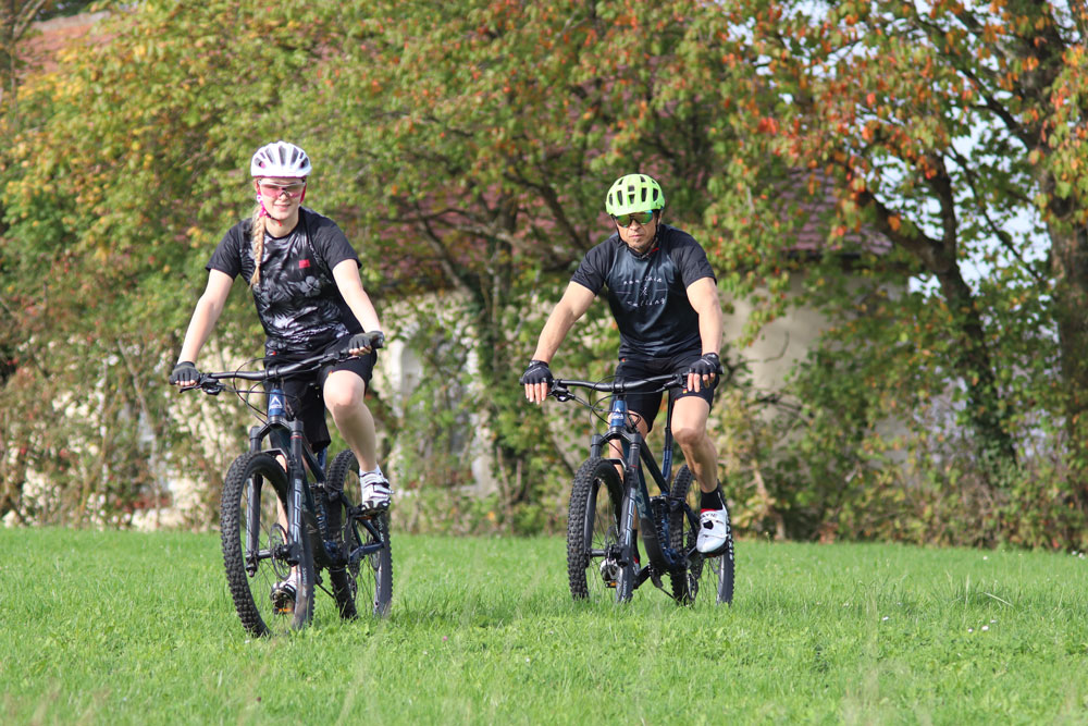 Zwei Radfahrer auf Mountainbikes mit DOWE MTB Trikots