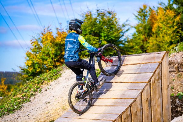 DOWE Sportswear Gravity Jersey, getragen von Mountainbiker des BikePark Albstadt - Grün-Blaues Camo-Muster - MTB-Radler an Rampe